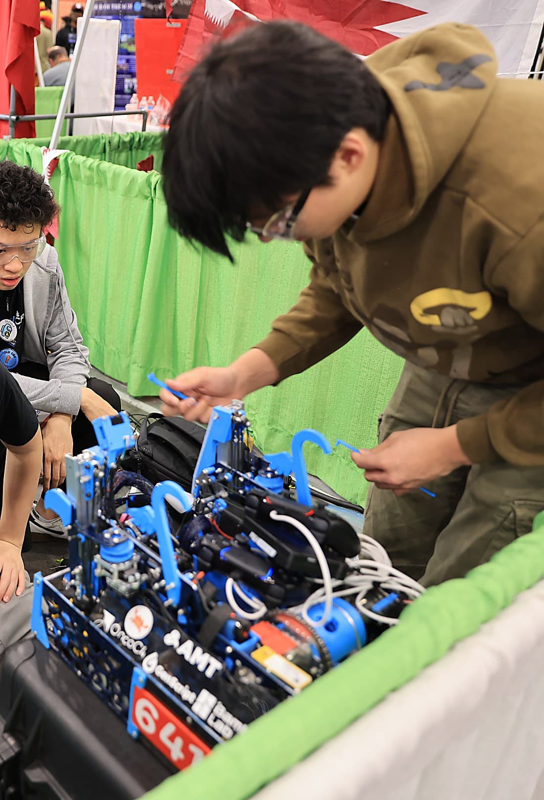 Cooper working on his FTC robot in the competition pit